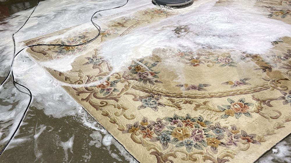 Dr. Carpet18 technician deep-washing an antique Aubusson rug during professional rug pickup and cleaning